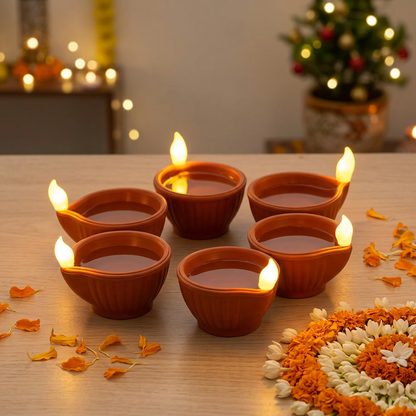 Six Classic Brown LED water diyas styled with flowers and rangoli in a festive setting